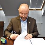 Zdjęcie przedstawia burmistrza podpisującego umowę.