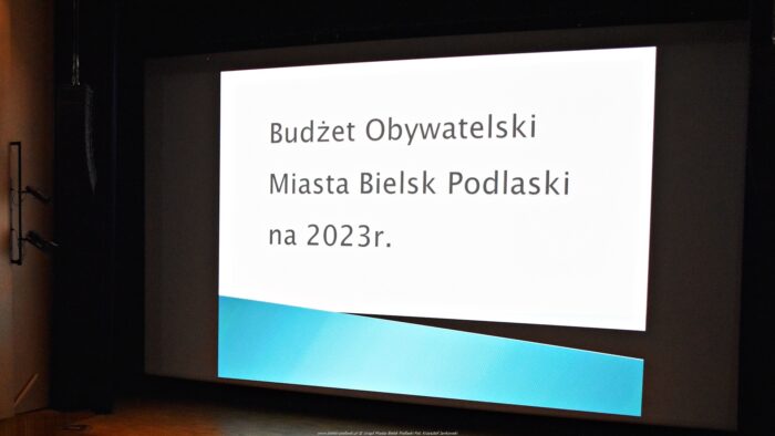 Plansza na ekranie sali kinowej Bielskiego Domu Kultury. Na białym tle czarny napis: "Budżet Obywatelski Miasta Bielsk Podlaski na 2023 r."