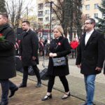 Pięcioosobowa delegacja radnych miasta Bielsk Podlaski idzie złożyć wieniec przed pomnikiem.
