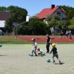 Dzieci i młodzież podczas gier i zabaw sportowych na boisku szkolnym.