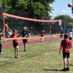 Dzieci i młodzież podczas gier i zabaw sportowych na boisku szkolnym.