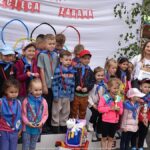 Uradowane dzieci na podium, z pucharami i medalami.