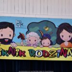 Baner z rysunkiem mężczyzny, kobiety i dwojga dzieci oraz napisem: "Piknik rodzinny"