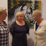 Trzy kobiety podczas rozmowy na wystawie w muzeum