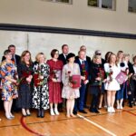 Nagrodzeni nauczyciele stoją w rzędzie razem z burmistrzem.