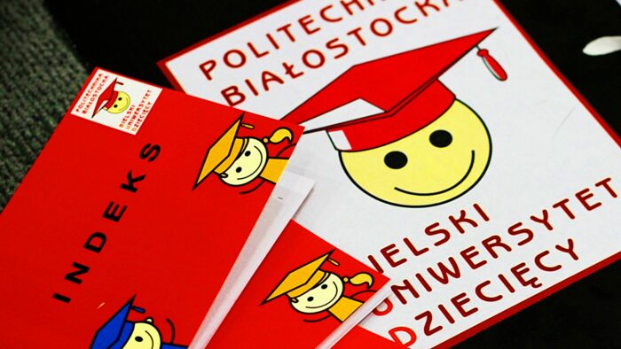 Zdjecie przedstawiające logotyp Bielskiego Uniwersytetu Dziecięcego - emotikonki radości w birecie (czapce studenckiej) i z nazwą projektu. Obok trzy czerwone indeksy z podobnym logotypem.
