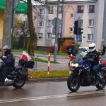 Przejazd motocyklistów ulicami miasta. Motocykle udekorowane są polskimi flagami.