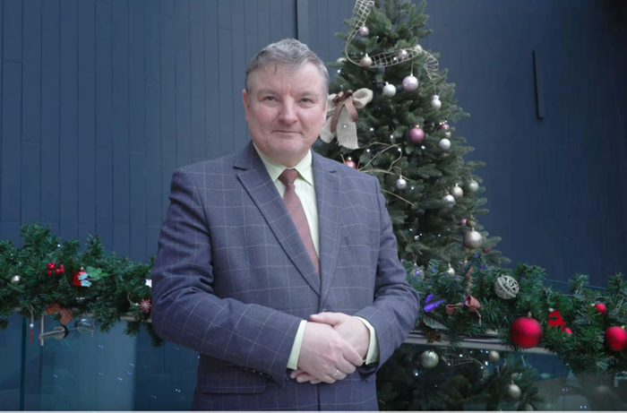 Burmistrz miasta Jarosław Borowski stoi na tle świątecznej choinki
