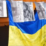 Niebiesko-żółta flaga Ukrainy oraz czarno-białe zdjęcia przedstawiające wojnę.