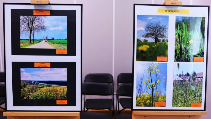 Dwie sztalugi z kolorowymi zdjęciami nagrodzonymi w konkursie.