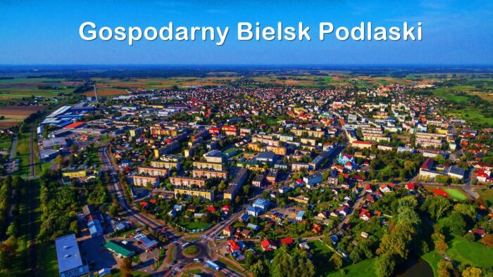 Widok całego miasta - zdjęcie z drona. Na tle nieba napis "Gospodarny Bielsk Podlaski".