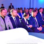 Księga pamiątkowa, a na drugim planie goście siedzący na sali.