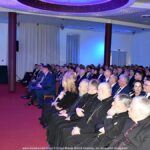 Mężczyzna przemawia do pełnej sali.