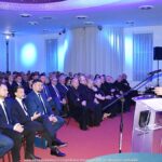 Mężczyzna przemawia do pełnej sali.