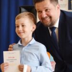 Burmistrz pozuje do zdjęcia z laureatem konkursu.