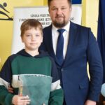 Burmistrz pozuje do zdjęcia z laureatem konkursu.