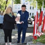 Składanie kwiatów przed pomnikiem.