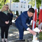 Składanie kwiatów przed pomnikiem.