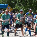 Zawody w nordic walkingu w lesie.