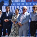 Zawody w nordic walkingu w lesie.