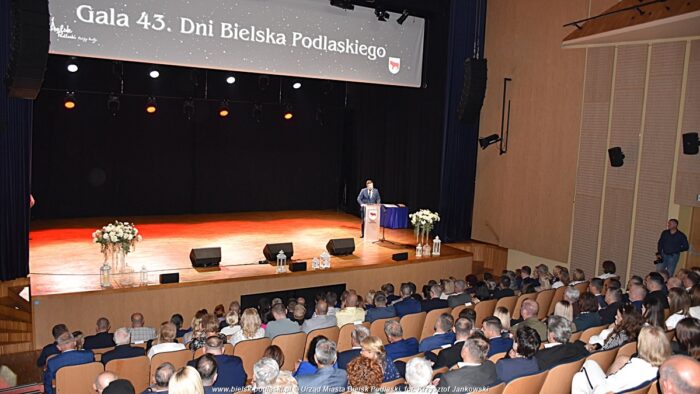 Widok szeroki na scenę w domu kultury. Na scenie stoi mężczyzna i przemawia. Nad sceną napis Gala 43. Dni Bielska Podlaskiego.