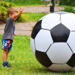 Festyn plenerowy w parku i bawiące się dzieci.