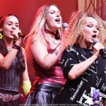 Koncert kolorowo ubranych wokalistek z zespołu Fart na scenie plenerowej.