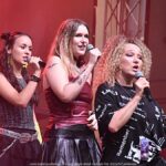 Koncert kolorowo ubranych wokalistek z zespołu Fart na scenie plenerowej.