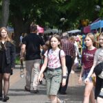 Jarmark Jagielloński w parku: stragany i zabawy dzieci na dmuchańcach.