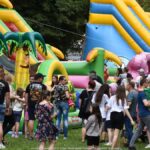 Jarmark Jagielloński w parku: stragany i zabawy dzieci na dmuchańcach.