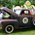 Jarmark Jagielloński w parku: stragany i zabawy dzieci na dmuchańcach.