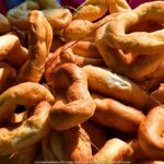 Jarmark Jagielloński w parku: stragany i zabawy dzieci na dmuchańcach.