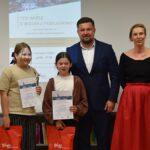 Dorośli i dzieci na turnieju wiedzy w bibliotece.