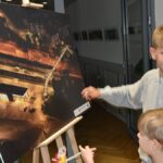 Wernisaż wystawy fotografii w bibliotece.