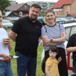 Pięć osób pozuje do zdjęcia w plenerze.