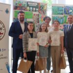 Uczniowie w towarzystwie opiekunów i gości prezentują dyplomy.