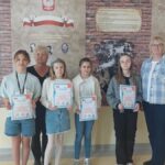 Uczniowie w towarzystwie opiekunów i gości prezentują dyplomy.