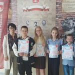 Uczniowie w towarzystwie opiekunów i gości prezentują dyplomy.