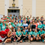 Pozowane zdjęcie grupy uczestników biegu przed ratuszem.