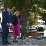 Uroczyste ustawianie płonących zniczy przed pomnikami.