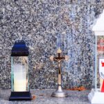 Dwa znicze i dwa krzyże przed pomnikiem.