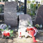 Zdjęcie mogiły z ustawionymi wielkimi kamieniami, na których są wygrawerowane napisy.