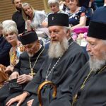 Księża prawosławni na widowni domu kultury.