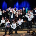 Grupowe zdjęcie na scenie: nagrodzonych artystów, organizatorów i jurorów.