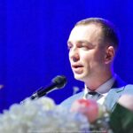 Mężczyzna przemawiający do mikrofonu.