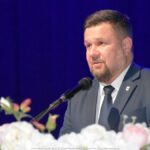 Mężczyzna przemawiający do mikrofonu.