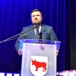 Mężczyzna przemawiający do mikrofonu.