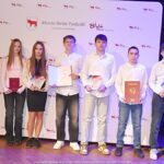 Nagrodzeni sportowcy i ich trenerzy pozują do zdjęcia.