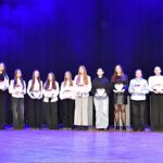 Nagrodzeni sportowcy i ich trenerzy pozują do zdjęcia.