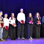 Nagrodzeni sportowcy i ich trenerzy pozują do zdjęcia.